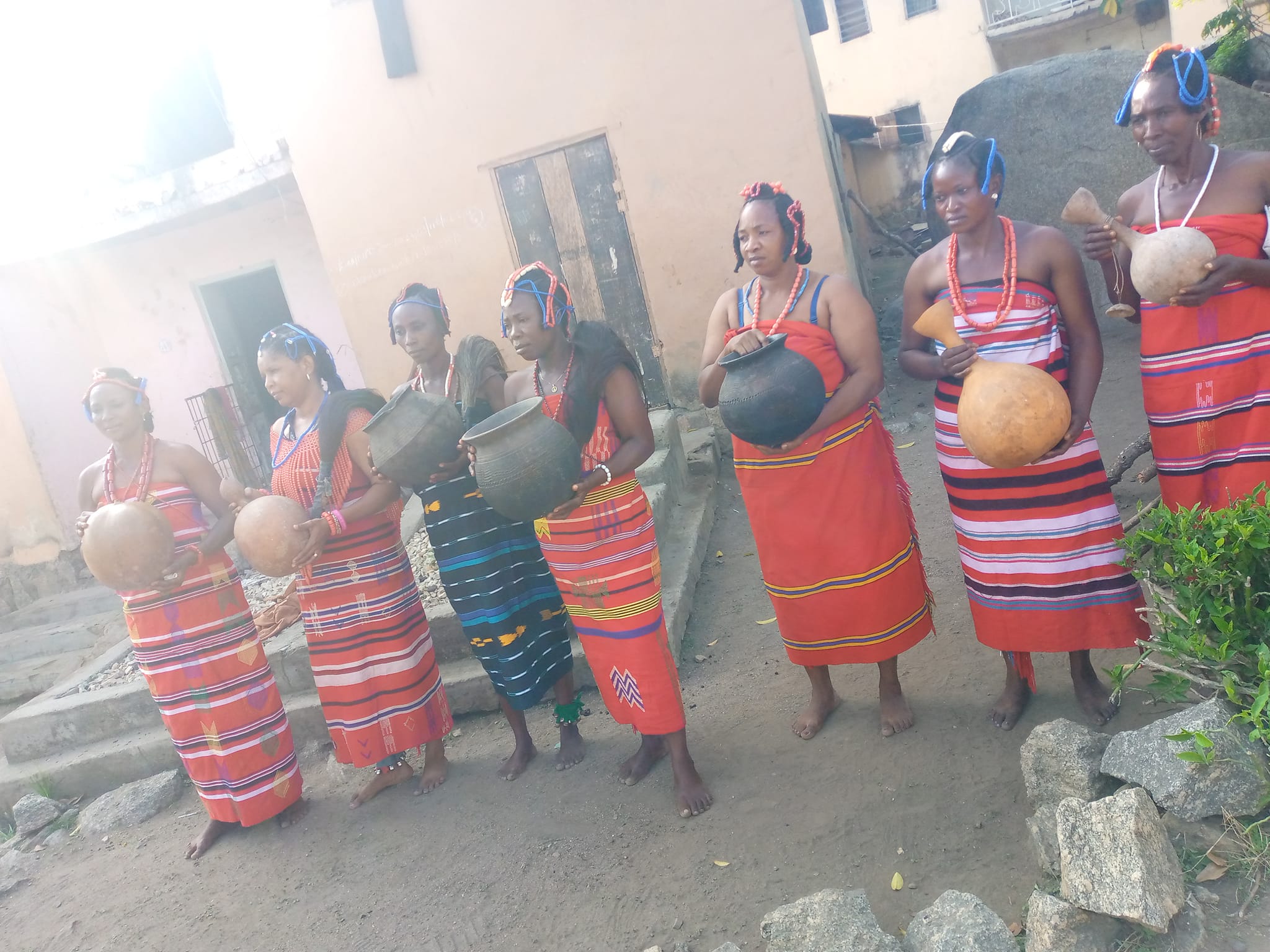 Beautiful Ososo ladies dressed in the traditional Ulalo fabric with calabash awaiting the arrival of their husbands and family members from camp